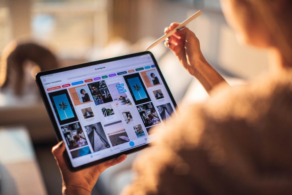 pexels-photo-3082341-3082341 A person uses a digital tablet with a stylus indoors in a warm, cozy setting.